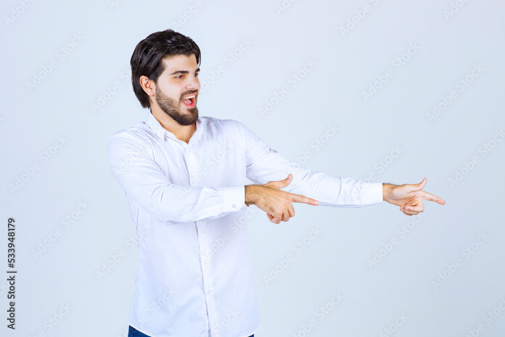 Man in white shirt pointing at something on the right