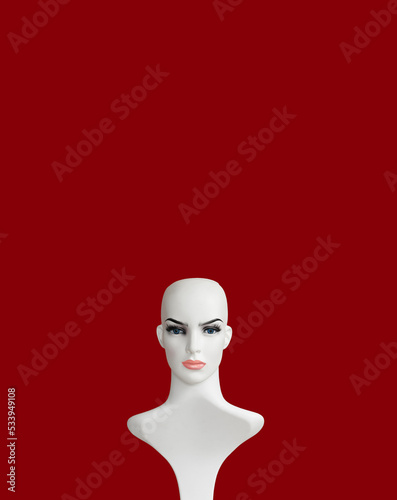 White plastic female mannequin  portrait on burgundy color background
