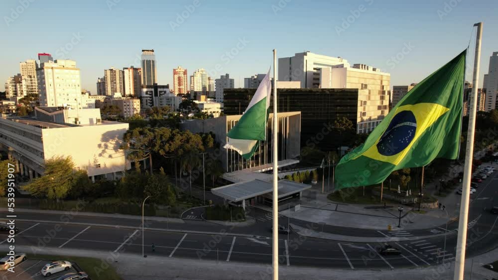 Vídeo gravado com drone no centro cívico de Curitiba. Imagem aérea das bandeiras e da Assembleia Legislativa do Estado, sede do poder legislativo, onde deputados votam projetos de lei. 