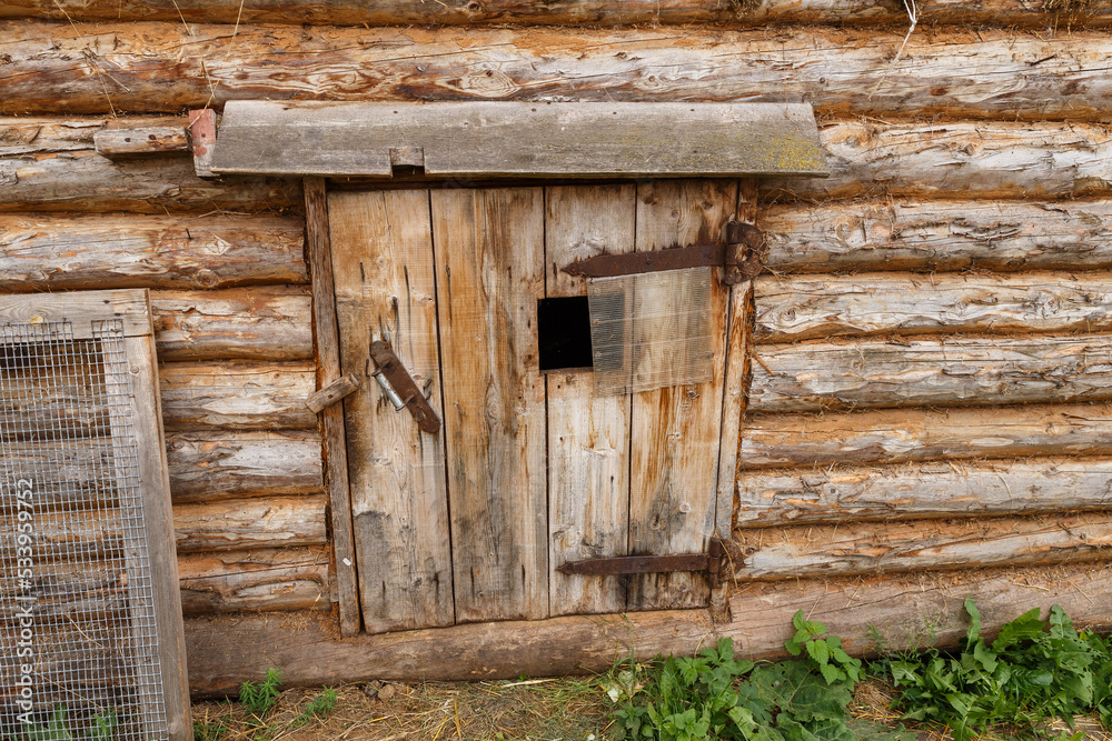 Animal stall. Closed door in a wooden barn. Entrance to the animal shed