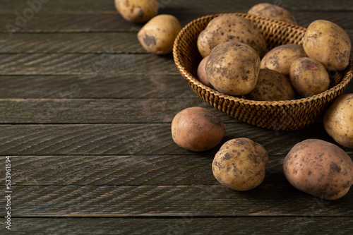 Rustic wooden background with raw potatoes roots food