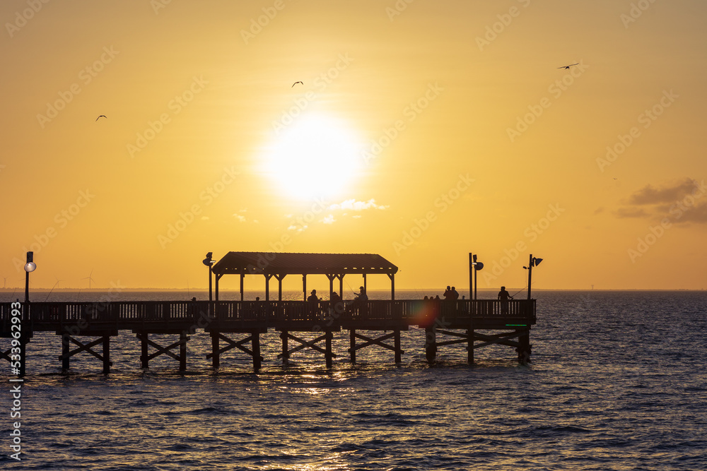 Sunset over an ocean pier in Port Isabel 