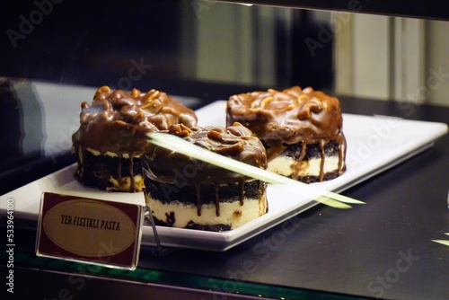 Closeup of delicious chocolate peanut cakes in the glass showcase