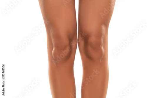 Front view of beautifully cared women's legs and knees on white background.