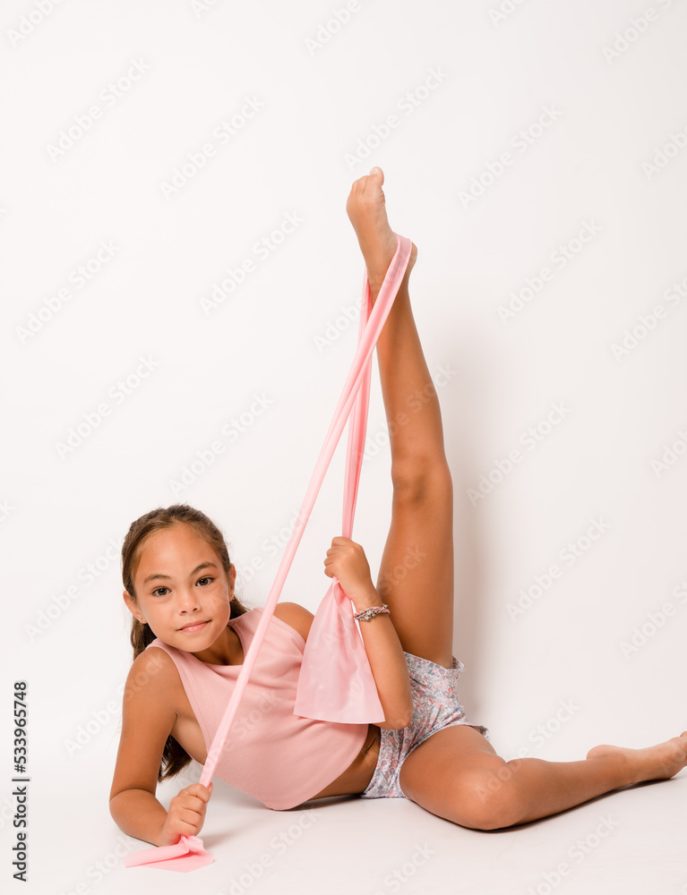 Full length photo of young attractive little girl sit floor stretching  training gym isolated over white color background Stock Photo