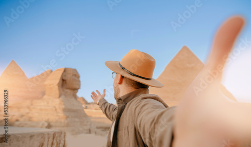 Travel Selfie photo man in hat background pyramid of Egyptian Giza and Sphinx  sunset Cairo  Egyp
