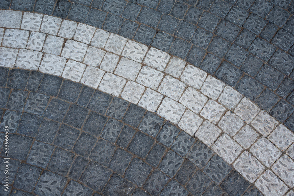 Detail of curved walkway with two different colored square cement light and dark pavers Detail of curved walkway with two different colored square cement light and dark pavers
