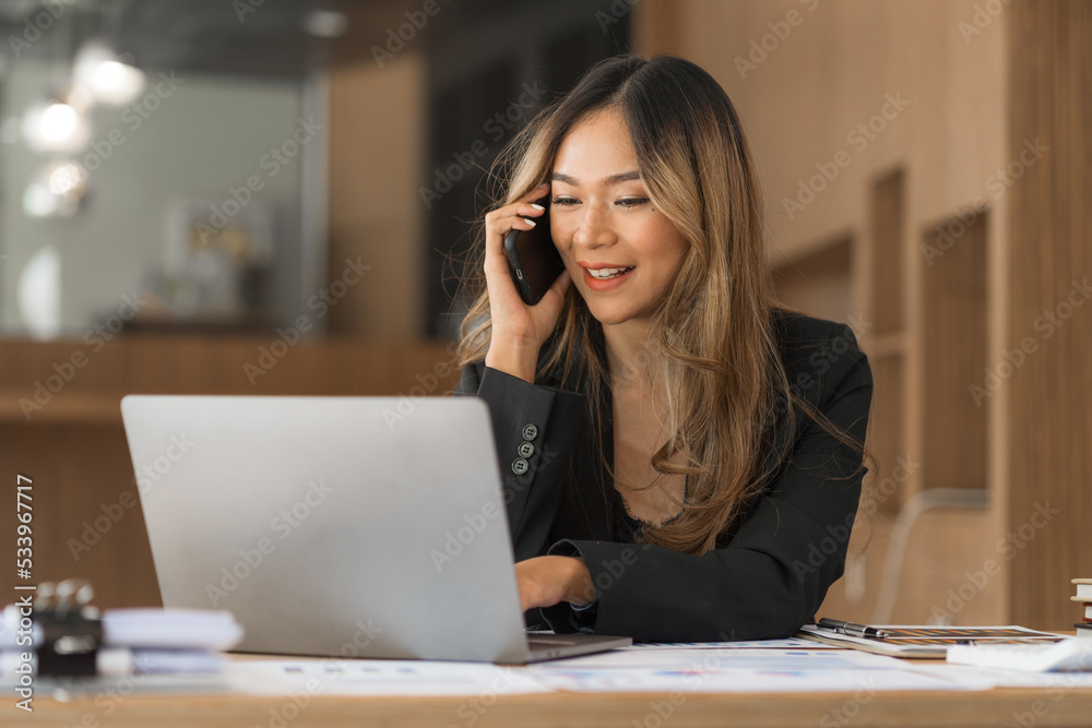 Using mobile, cheerful young asian business woman working at working place. Using mobile, cheerful young asian business woman working at working place.