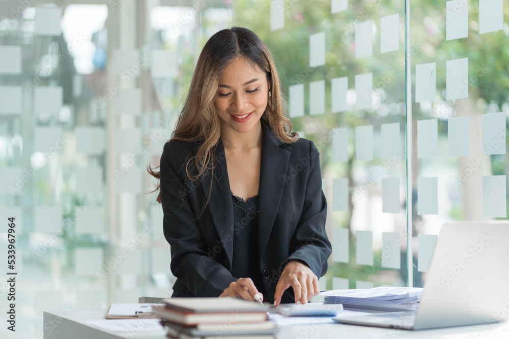 © Phushutter - Confident asian businesswoman working in office workstation. © Phushutter - Confident asian businesswoman working in office workstation.