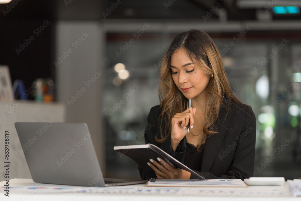 Confident asian businesswoman working in office workstation. Confident asian businesswoman working in office workstation.