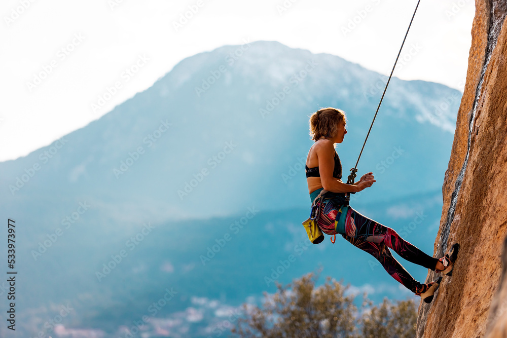 girl rock climber hanging on a rope.