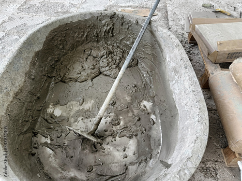 Make concrete with sand, water, cement in tray. Mix ingredients with hoes for walkway tile flooring construction
