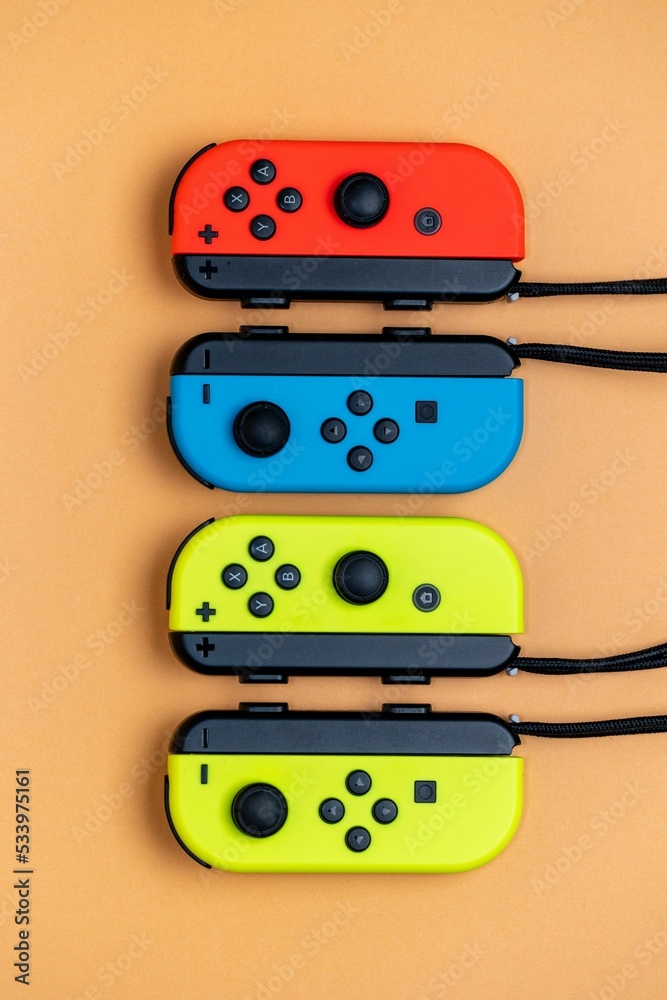 Nintendo Switch JoyCons aligned in a row. Yellow blue and red JoyCons