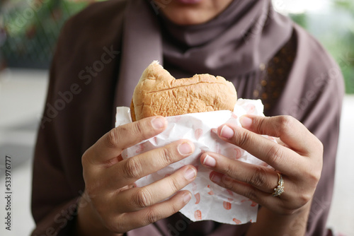women hand holding beef burger top view 