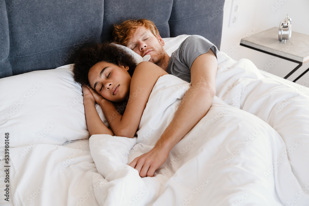 Young multinational couple hugging and sleeping together at home Young multinational couple hugging and sleeping together at home