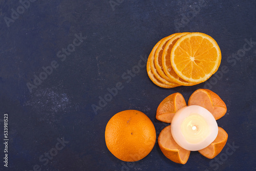 Sliced oranges in a pile on blue background