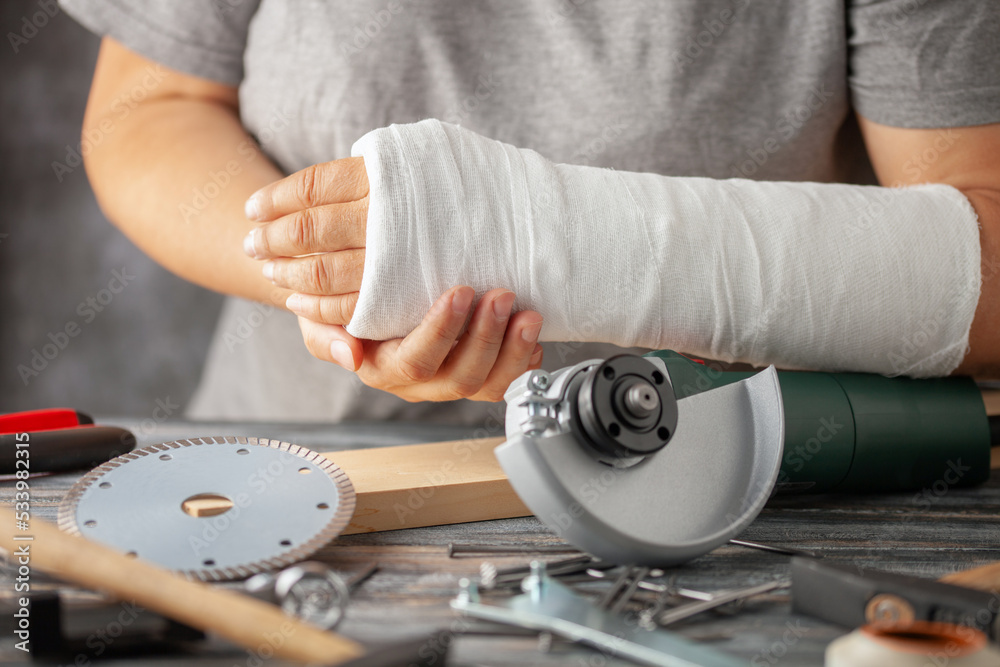 Broken arm. Hand in plaster and building tools