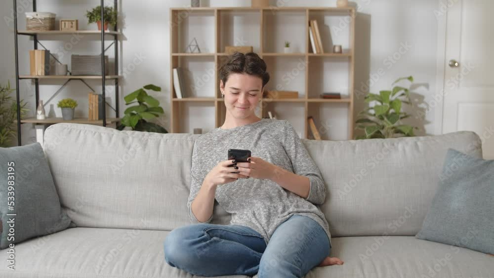 Woman relaxing on comfort couch using smart phone device Woman relaxing on comfort couch using smart phone device