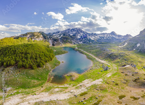Fototapeta Naklejka Na Ścianę i Meble -  Mountain lake landscape on Durmitor mountain in Montenegro beautiful Durmitor National park with lake glacier and reflecting mountain Portrait of a disgruntled girl sitting at a cafe table
