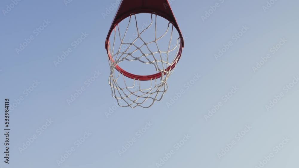 Basketball ball scoring the winning points on basketball net hoop on outdoor basketball court Basketball ball scoring the winning points on basketball net hoop on outdoor basketball court