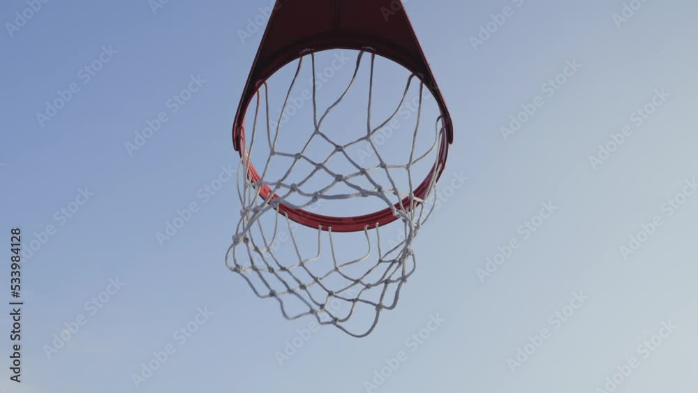 Basketball ball scoring the winning points on basketball net hoop on outdoor basketball court