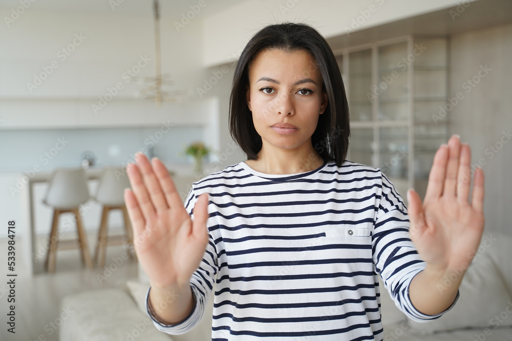 Serious woman showing stop hand gesture protesting against domestic violence, abuse or abortion Serious woman showing stop hand gesture protesting against domestic violence, abuse or abortion