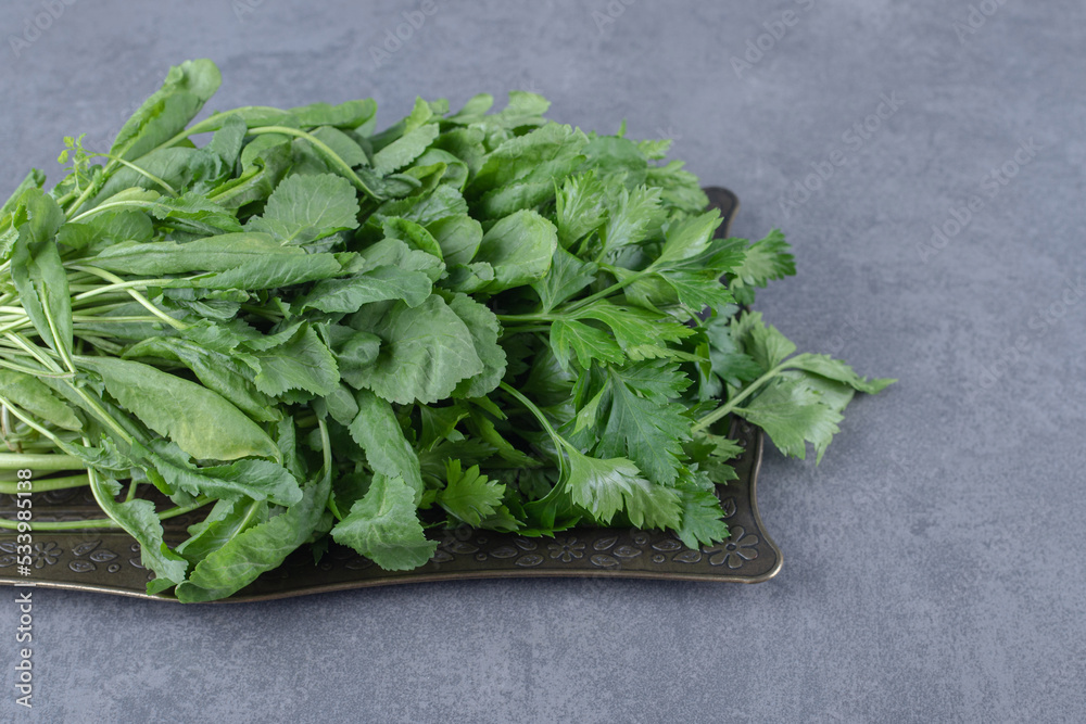 Fresh watercress on a tray, on the marble background Fresh watercress on a tray, on the marble background