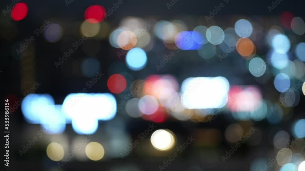Blurry film grain background of Abstract bokeh lights. Abstract city night lights illuminated blurred urban background. unfocused road traffic at night. horizontal Big city life