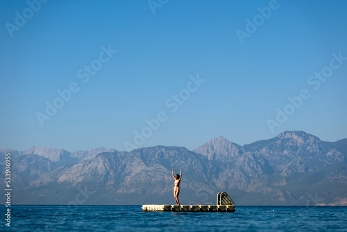 woman dancing on the pontoon at the sea 