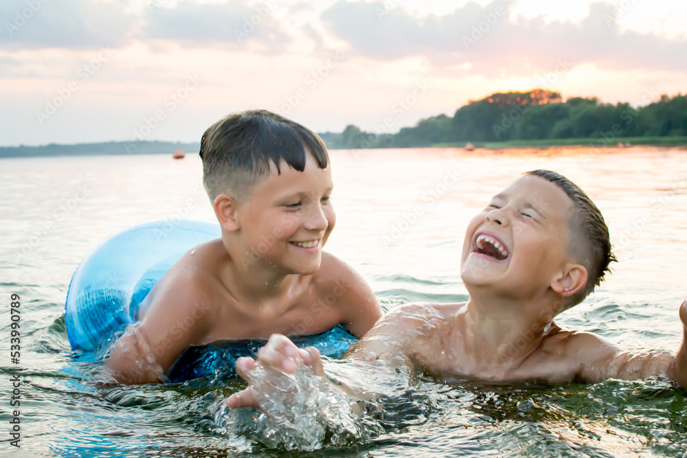 The brothers swim in the lake. Summer evening. Lake Myastro The brothers swim in the lake. Summer evening. Lake Myastro