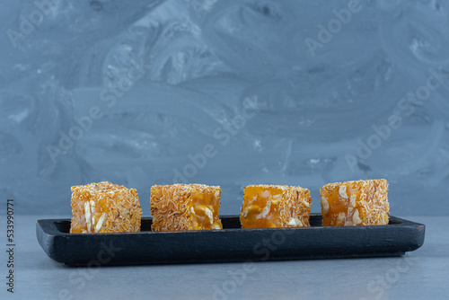 Tasty Turkish delight flavors on a wooden board, on the tea towel, on marble background