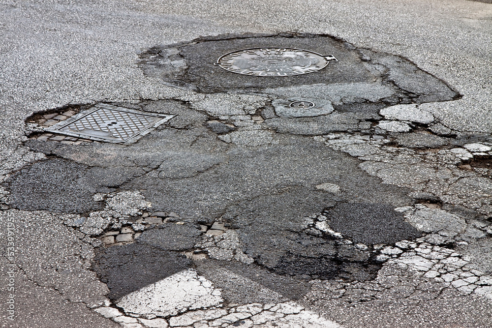 Old damaged, dangerous and broken asphalt road background Stock Photo