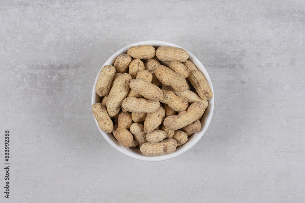Bowl of shelled peanuts on marble background Bowl of shelled peanuts on marble background
