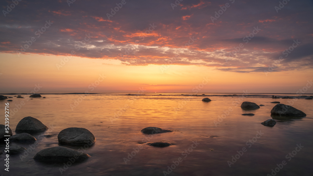 Calm orange sunset on the evening sea