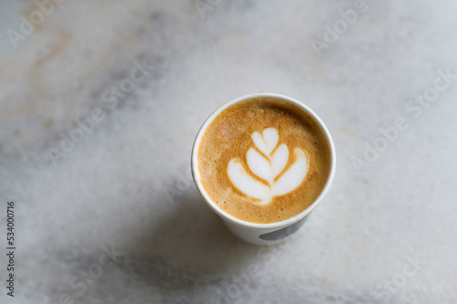 Hot cappuccino or latte art on white marble background.