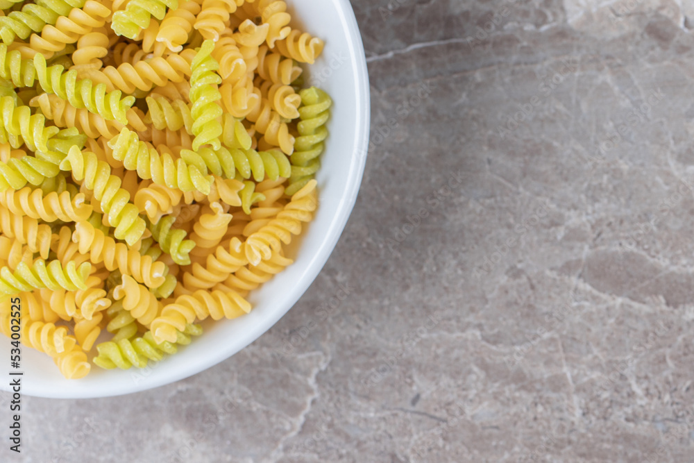 A bowl of mixed pasta , on the marble background A bowl of mixed pasta , on the marble background
