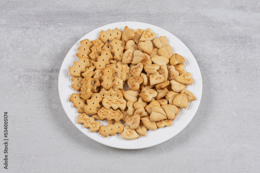 Pile of salted crackers on white plate Pile of salted crackers on white plate