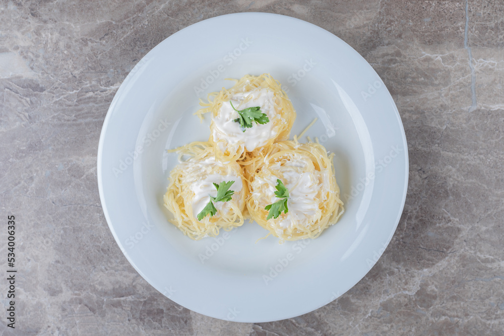 Spaghetti, yogurt and green vegetable on the plate , on the marble background