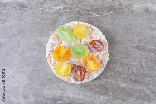 Different kinds of fruits on the puffed rice cakes, on the marble background