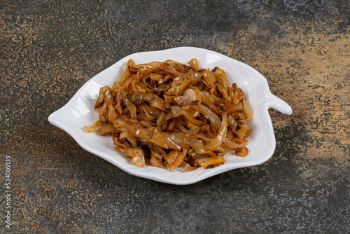 Fried caramelized onion pieces on leaf shaped plate