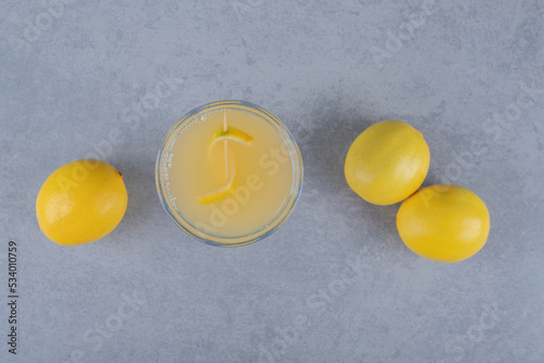 Fresh lemons with glass of juice