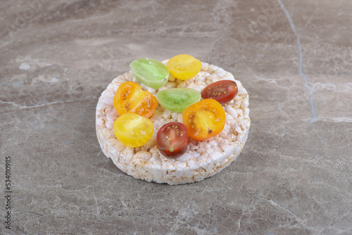 Different kinds of fruits on the puffed rice cakes, on the marble background