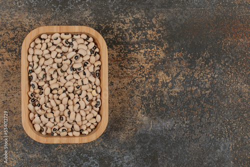 Pile of dry white beans on wooden plate
