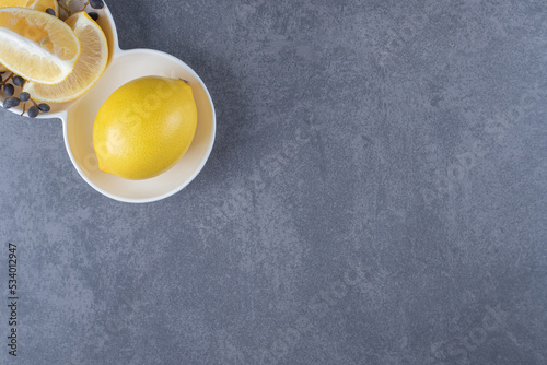 Fresh lemon and lemon slices on grey background