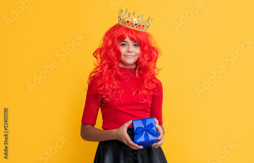 positive child in crown with present box on yellow background