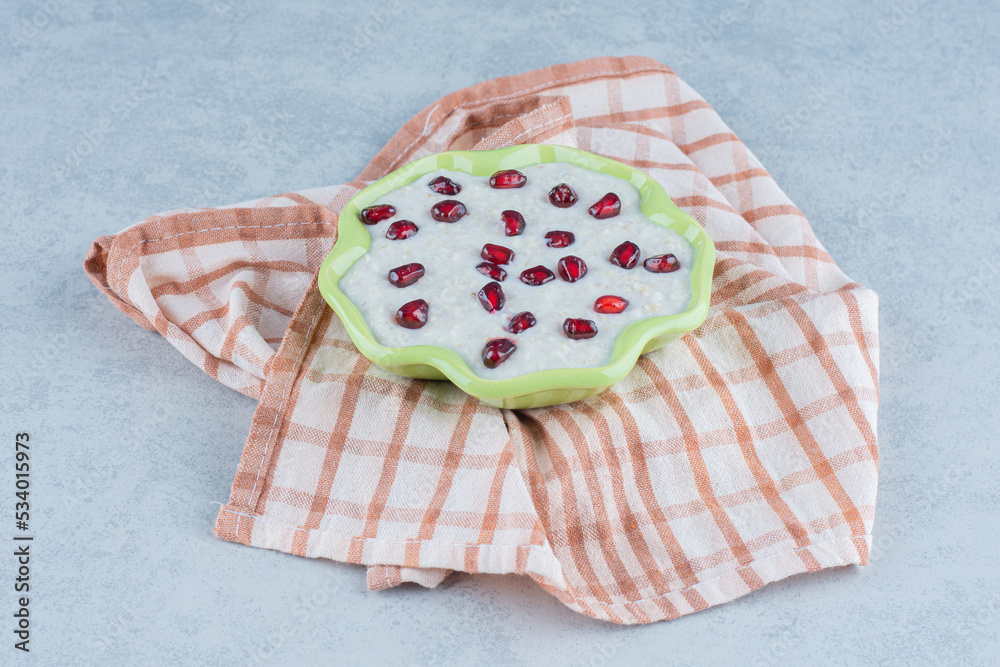 A plate of porridge, on towel, on the marble background A plate of porridge, on towel, on the marble background