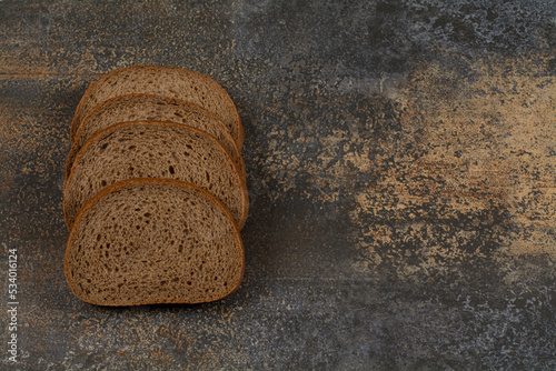 Sliced black rye bread on marble background