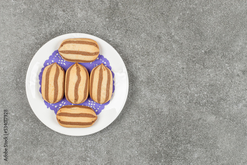 Delicious chocolate striped biscuits on white plate