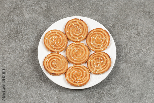 Plate of delicious round biscuits on marble background