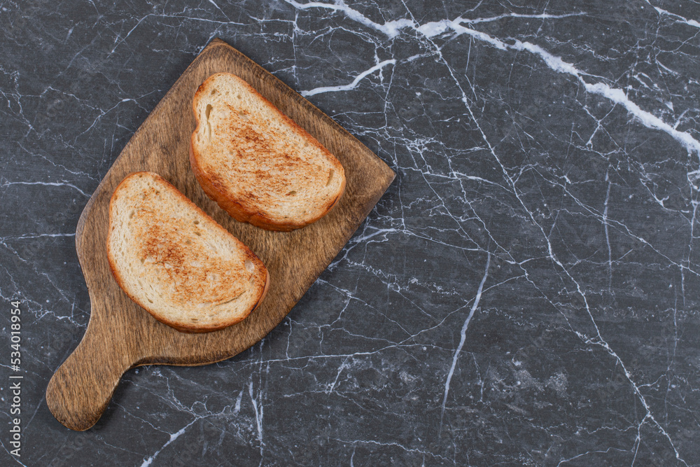 Two piece of fried bread on board , on the marble background Two piece of fried bread on board , on the marble background